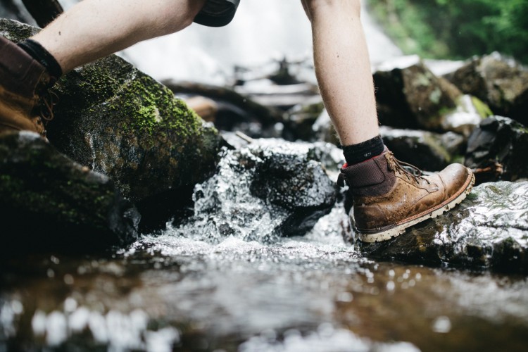 Man In Hiking Boots Walking Through Creek